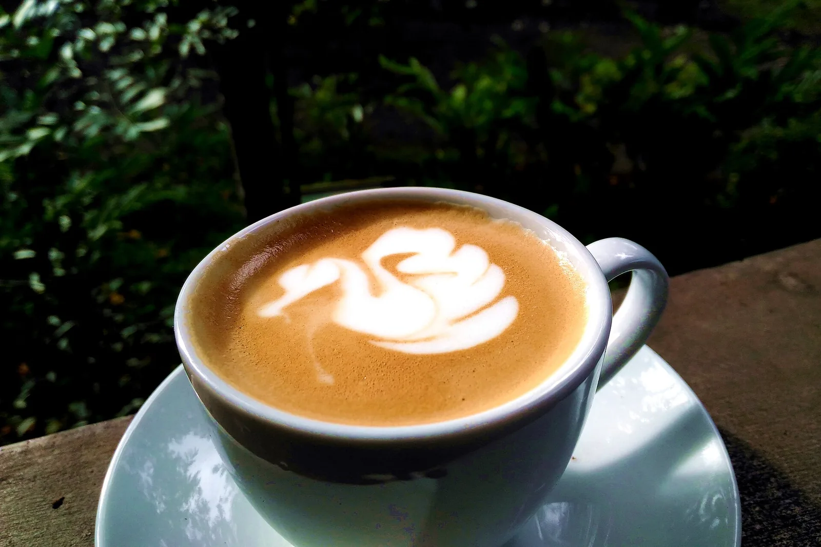 A cup of coffee with latte art on a cafe table. The photo was not taken in Brentwood.