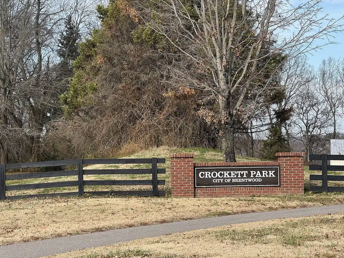 The brick Crockett Park sign reading "City of Brentwood" beside a paved path in Brentwood