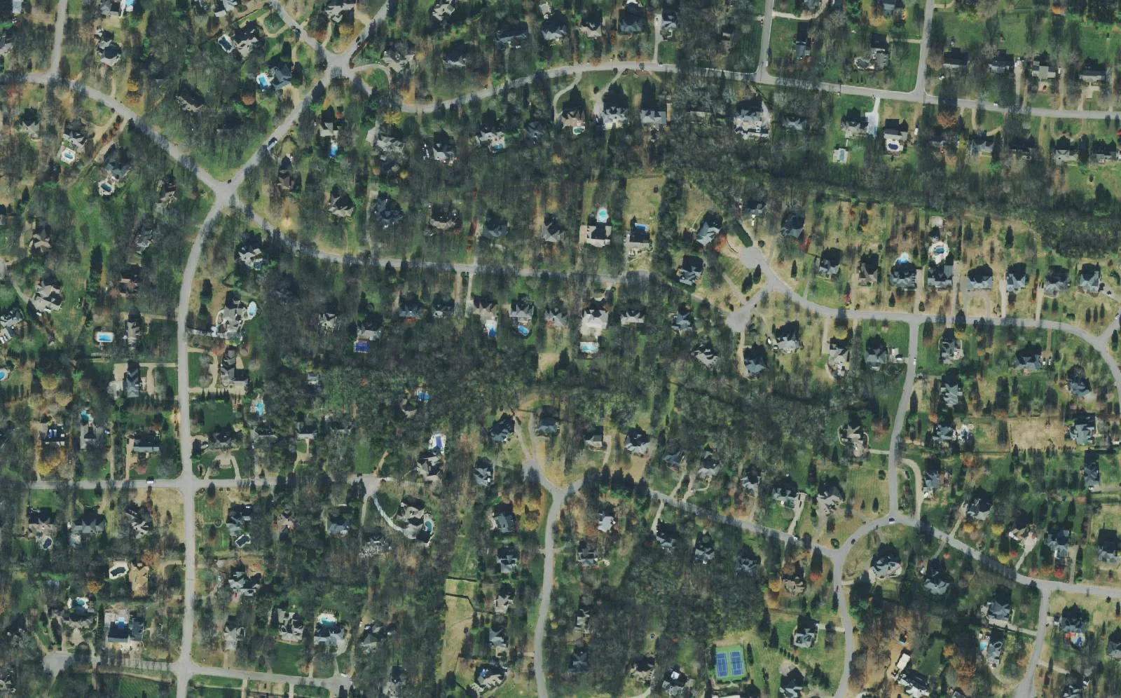 Houses on wooded lots along curving streets in the Wilson Pike area of Brentwood, north of Concord Road, seen from the air.