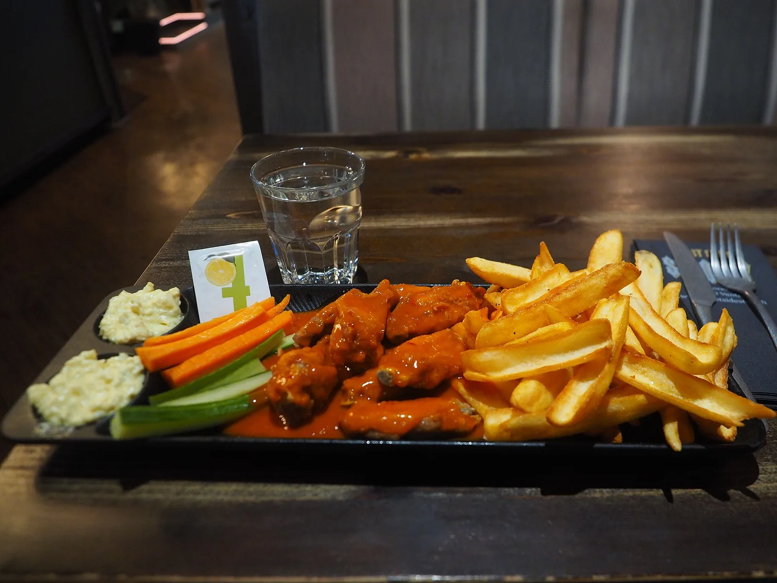 A plate of Buffalo chicken wings with fries, carrots and celery. The photo was not taken at a Brentwood restaurant.